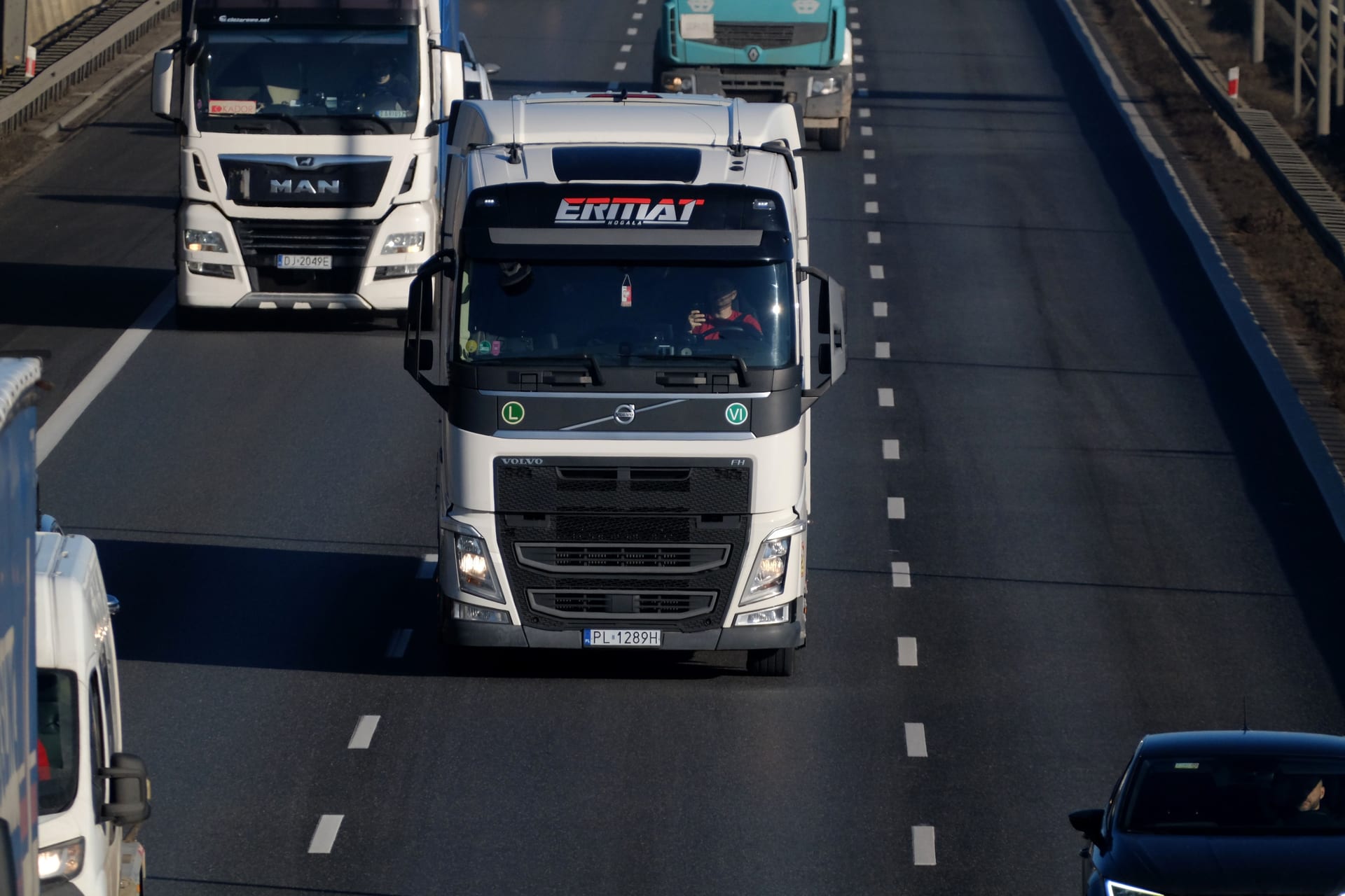 Camion pe autostradă, cu alte camioane de marfă în trafic